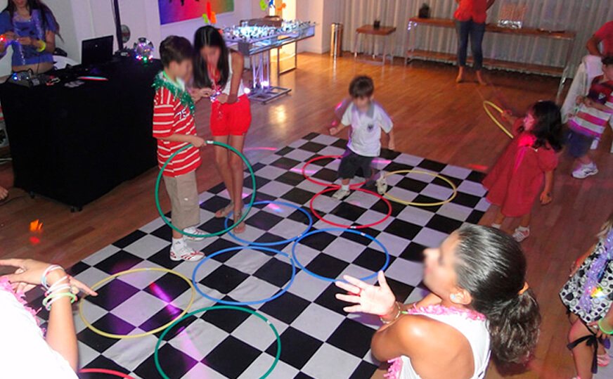Animadores com crianças brincando em salão de festas